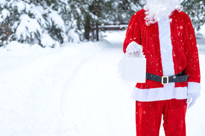 Midsection of woman standing on snow covered field during winter