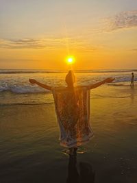 Man on beach against sky during sunset