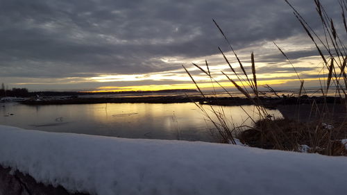 Scenic view of snow covered landscape against cloudy sky