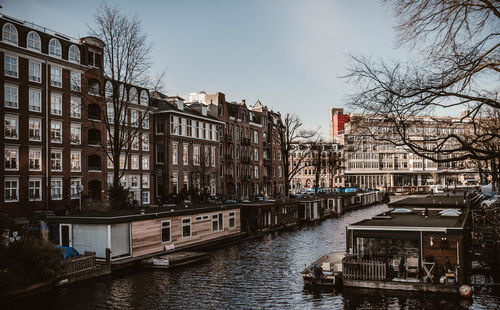 Canal amidst buildings in city against sky