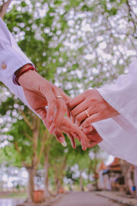 Midsection of couple holding hands