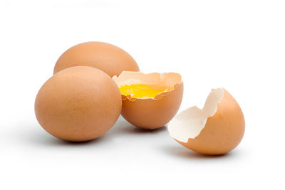 Close-up of broken egg against white background