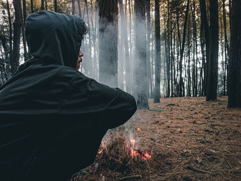 Rear view of woman standing in forest