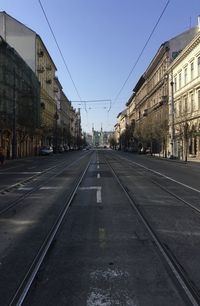 Surface level of railroad tracks by buildings against sky