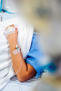 Close-up of woman hand with medical equipment on bed