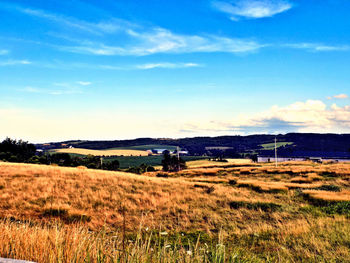 Scenic view of field against cloudy sky