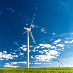 Low angle view of windmill on field against sky