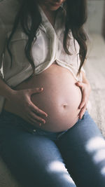 Midsection of woman sitting at home