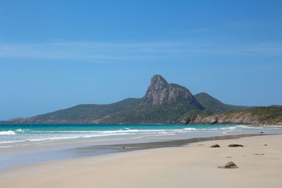 Scenic view of beach against blue sky