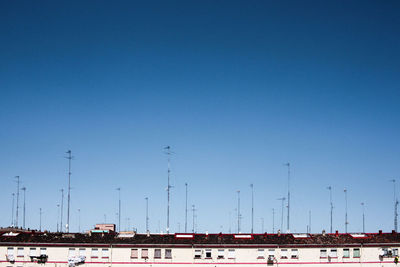 Sailboats in city against clear blue sky
