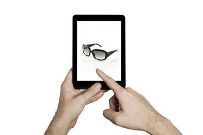 Low section of man using smart phone against white background