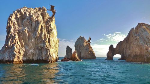 Panoramic view of rock formation in sea against sky