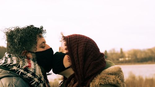 Couple kissing with face masks on during the coronavirus pandemic 