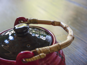 The red chinese teapot on a wooden table, close-up