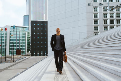 Full length of young man standing against building