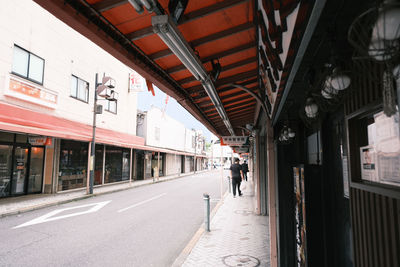 People walking on street amidst buildings in city