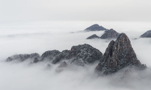 Scenic view of mountains during foggy weather against sky