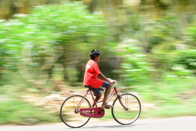 Side view of man riding bicycle