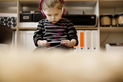 Girl listening to music while using phone at home