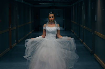 Portrait of woman standing against wall