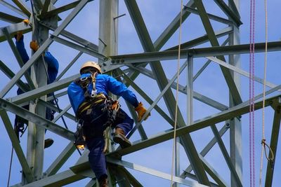 Low angle view of men on tower against sky