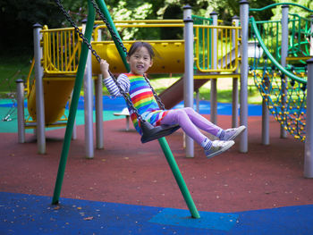 Full length of boy swinging at playground