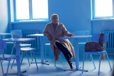 Woman sitting on chair in table