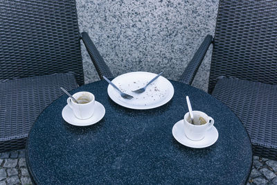 High angle view of empty plates and cups on table