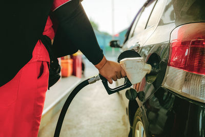 An officer at a gas station at work refueling a car