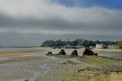 Scenic view of beach against cloudy sky