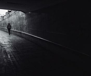 Rear view of man walking in tunnel