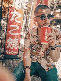 Midsection of man standing by graffiti on wall