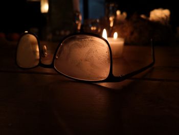 Close-up of illuminated light bulb on table