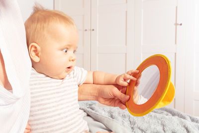 Portrait of cute baby boy lying on bed at home