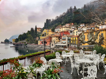 Scenic view of river by buildings against sky