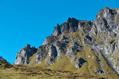 Rock formations against clear blue sky