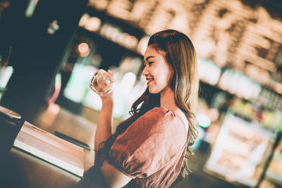 Side view of a young woman holding ice cream