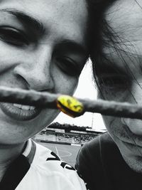 Close-up portrait of young woman holding cigarette