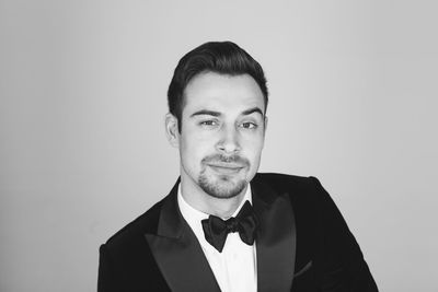 Portrait of young man standing against white background