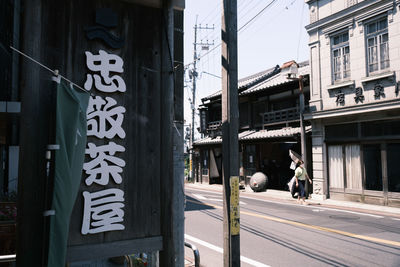 Information sign on street by buildings in city