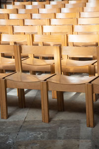 Empty wooden chairs arranged in a row