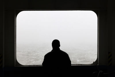 Man looking through window of boat