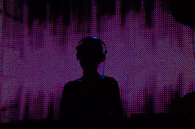 Silhouette dj playing music at night club