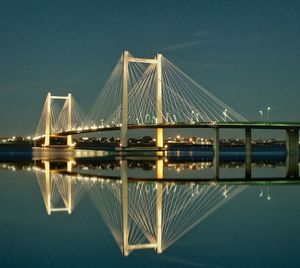 Low angle view of suspension bridge against sky at night