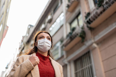 Low angle view of woman against building