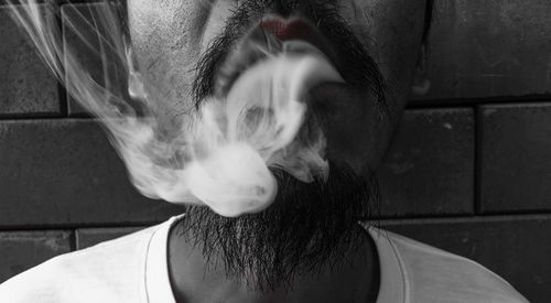 Close-up of man exhaling smoke