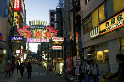 People walking on illuminated street at night