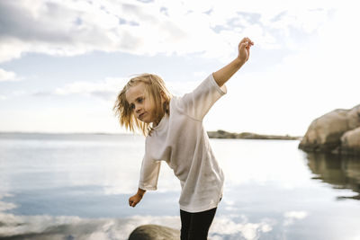 Girl at sea with arms outstretched