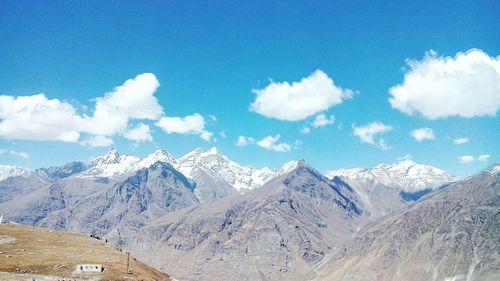 Scenic view of snowcapped mountains against cloudy sky