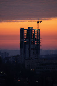 Silhouette built structures against sky during sunset